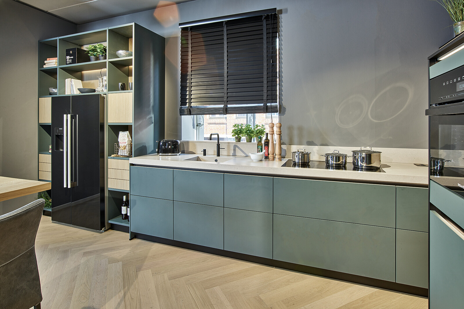 Showroomkeuken: Groene hoekkeuken met licht eiken van next125 - designkeuken in kobaltgroen en eiken select