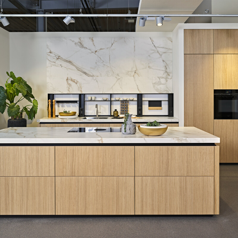 Japandi keuken met licht eiken lamellen fronten. Fronten met ribbels. Designmerk next125 NX670. Te zien bij Ekelhfof Küchen in Nordhorn, net over de grens.