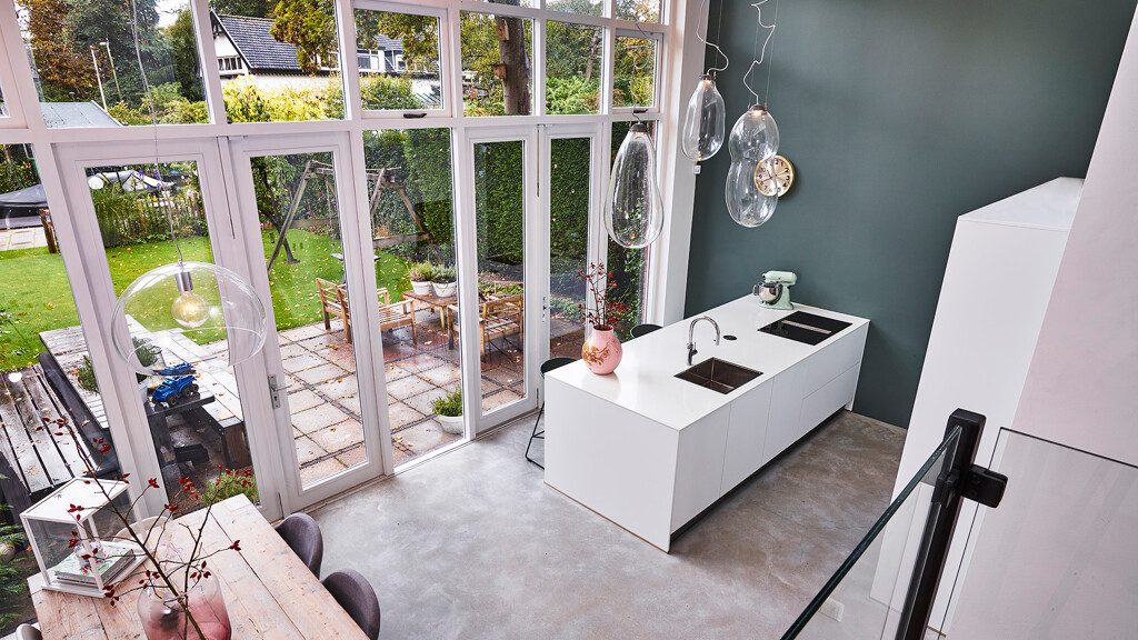 Schlichte grifflose Inselküche in Mattweiß mit weißer Arbeitsplatte in Marmoroptik von Ekelhoff Küchen